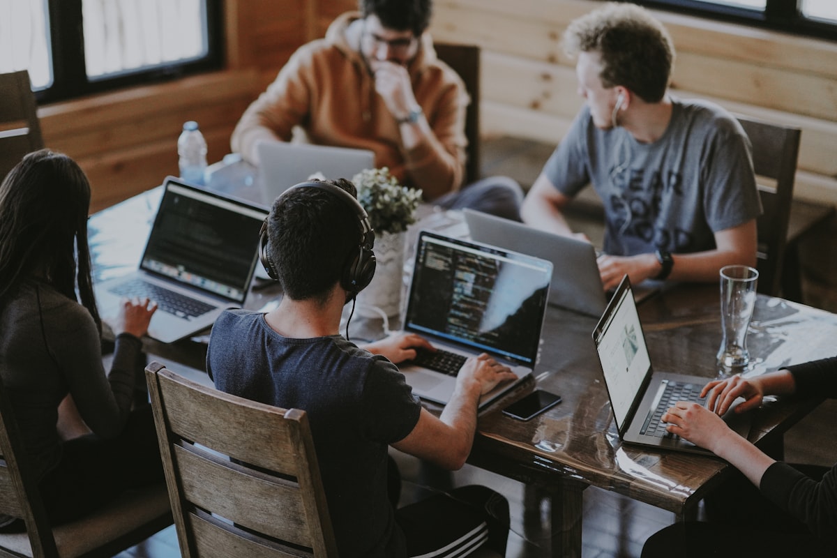 Perth business team collaborating at laptops in a modern office